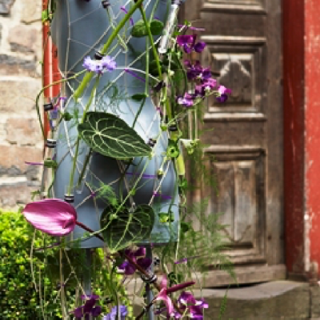 Schneiderpuppe mit lila Blumen umwickelt